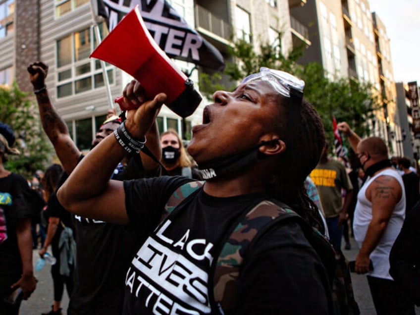 LOUISVILLE, KY - SEPTEMBER 26: A woman leads leads the crowd in chants as hundreds of demo