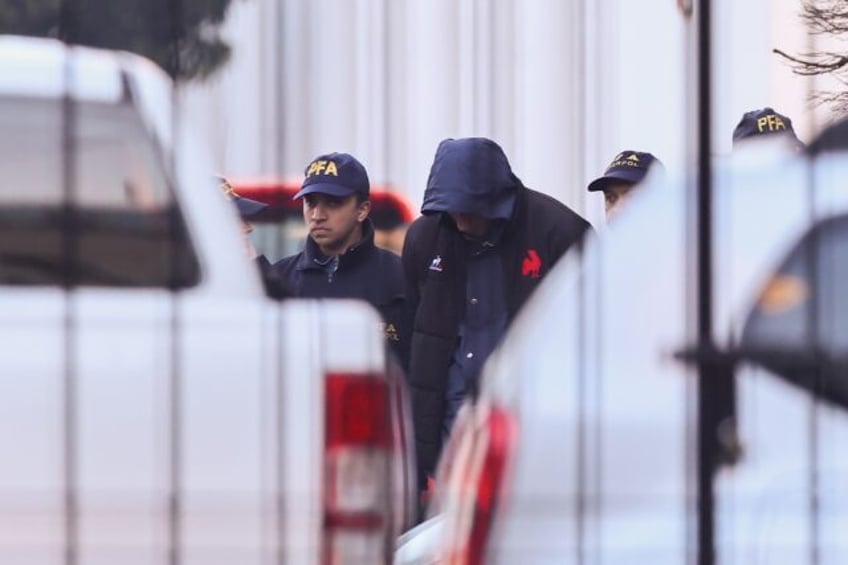 French national rugby player Oscar Jegou (C) is escorted by Argentinian federal police as