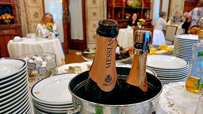 Two open bottles of sparkling wine sit in a silver ice bucket.