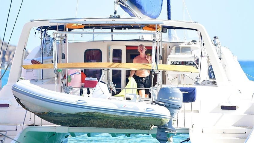Ryan Bane standing shirtless on the back of his boat
