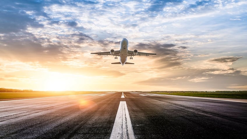 Airplane Taking Off with sunrise behind it