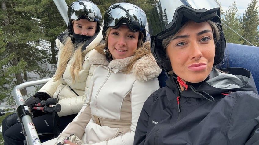 Friends sit on a chairlift in the snow, ready to go skiing. Left to right friends Laura, Olivia and Anastasia pictured minutes before Olivia suffered an horrific accident.