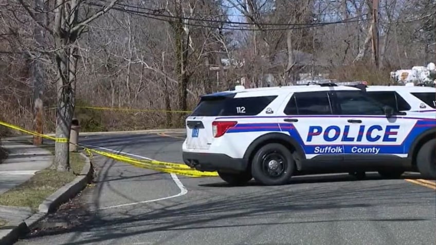 A police vehicle and police tape at a crime scene