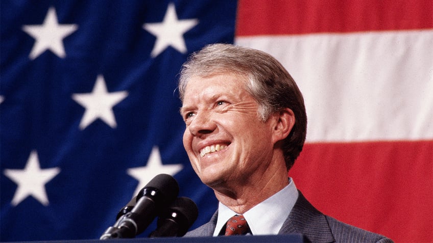 Jimmy Carter standing in front on the American flag