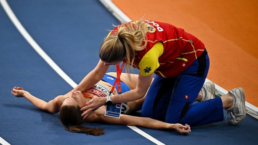 Maureen Koster of Netherlands receives medical attention after collapsing on the track during the women's 3000m final on day four of the European Athletics Indoor Championships 2025 at the Omnisport Apeldoorn in Apeldoorn, Netherlands.