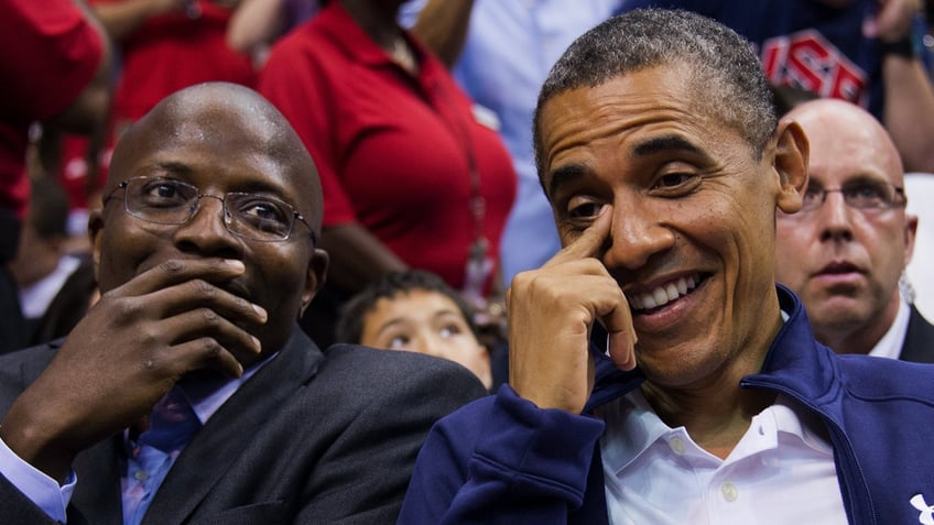 Reggie Love and Barack Obama sitting next to each other