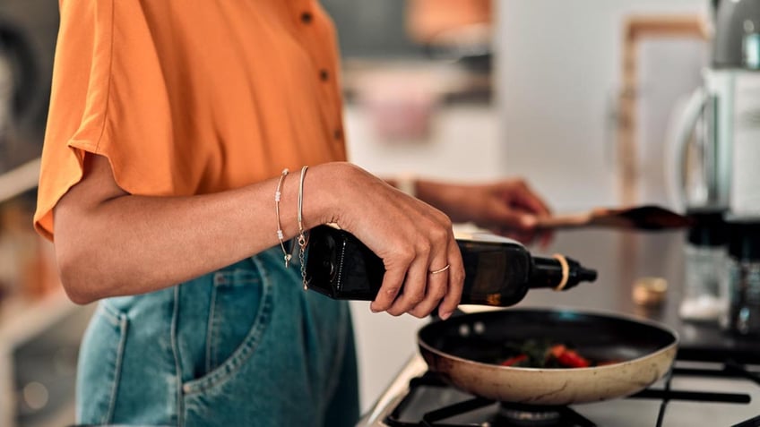 Woman cooking with oil