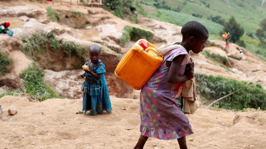 A girl carries a container of water