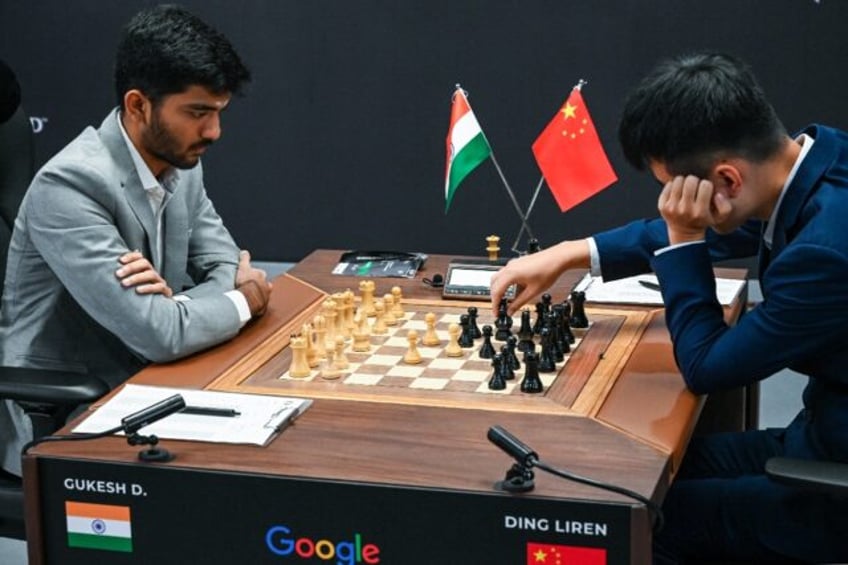 China's chess grandmaster Ding Liren (R) and Indian grandmaster Gukesh Dommaraju remain ti