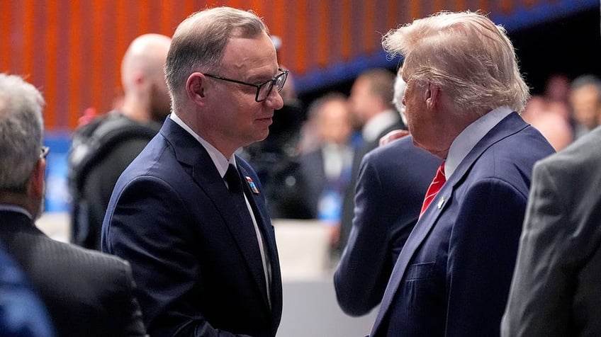 President Donald Trump shakes hands with Poland's President Andrzej Duda during a plenary session at the NATO summit.