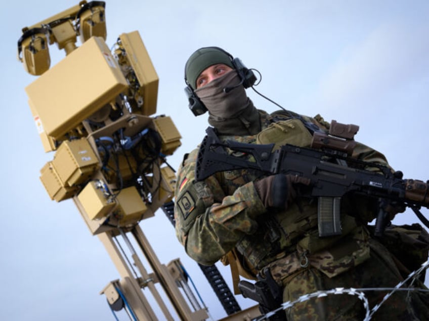 05 December 2023, Romania, Constanta: A Bundeswehr soldier stands in front of a defense system against small unmanned aerial vehicles (ASUL) to protect the contingent at the Mihail Kogalniceanu airfield near Constanta (Romania). The German Air Force is currently supporting NATO member Romania with Eurofighter combat aircraft and a defense …