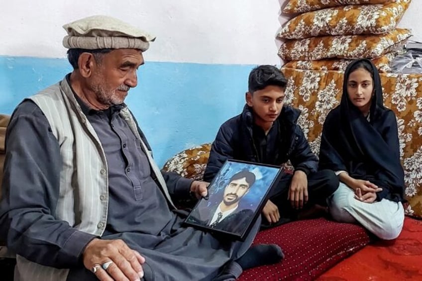 Ali Ghulam holding a portrait of his nephew Gulfam Hussain, who was killed in sectarian cl