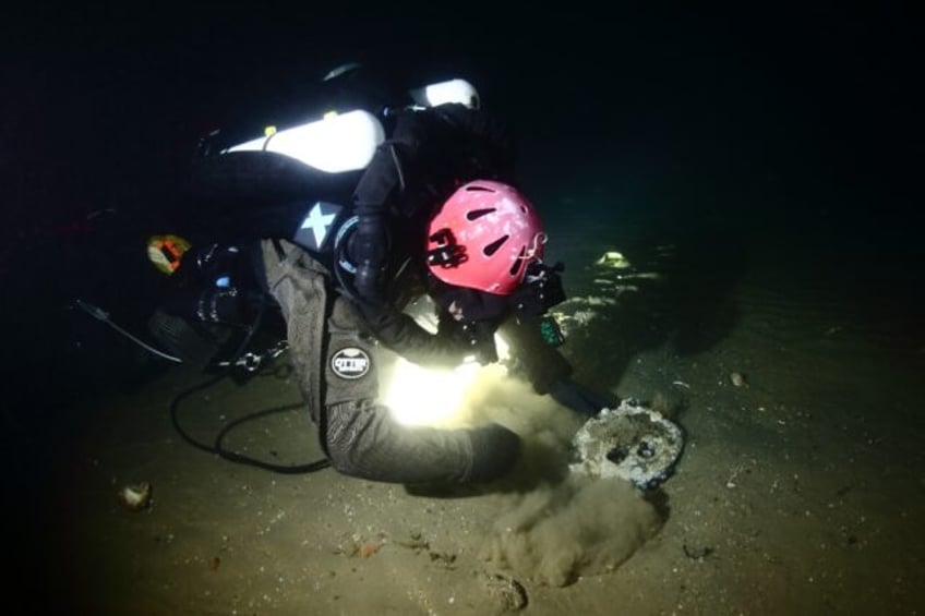 A handout image from Atlantic Wreck Salvage shows diver Joe Mazraani fanning away sand to