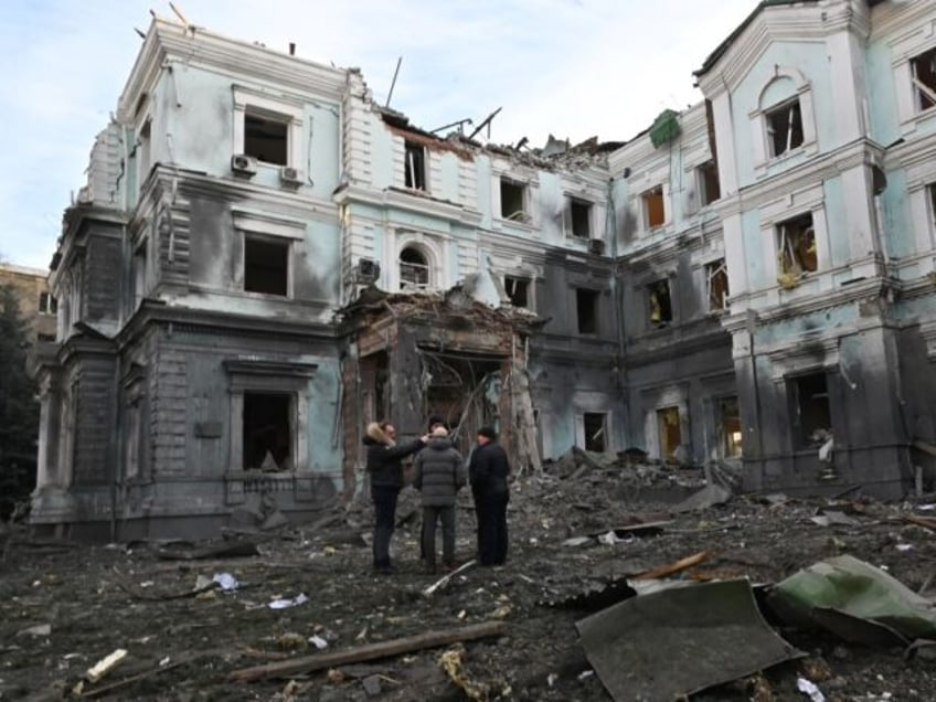 TOPSHOT - Local residents talk outside a heavily damaged building in Kharkiv on January 24, 2024 one day after after a Russian missile barrage across the country. (Photo by SERGEY BOBOK / AFP) (Photo by SERGEY BOBOK/AFP via Getty Images)