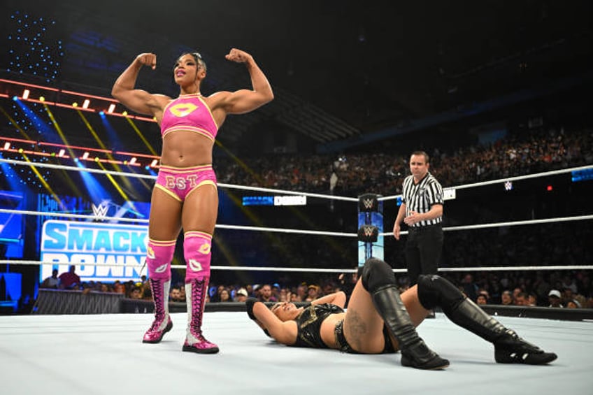 Bianca Belair poses over Michin as she reacts during their Money in the Bank qualifying triple threat match during WWE SmackDown at Allstate Arena on...