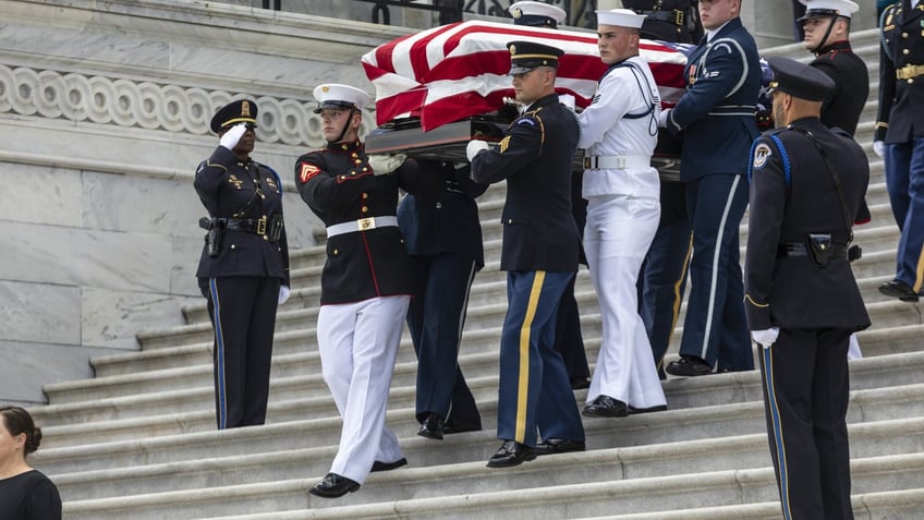 coffin draped in flag carried out