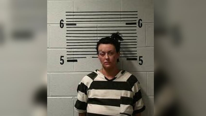 Grace Kelley wears black and white jail uniform in Alabama mugshot