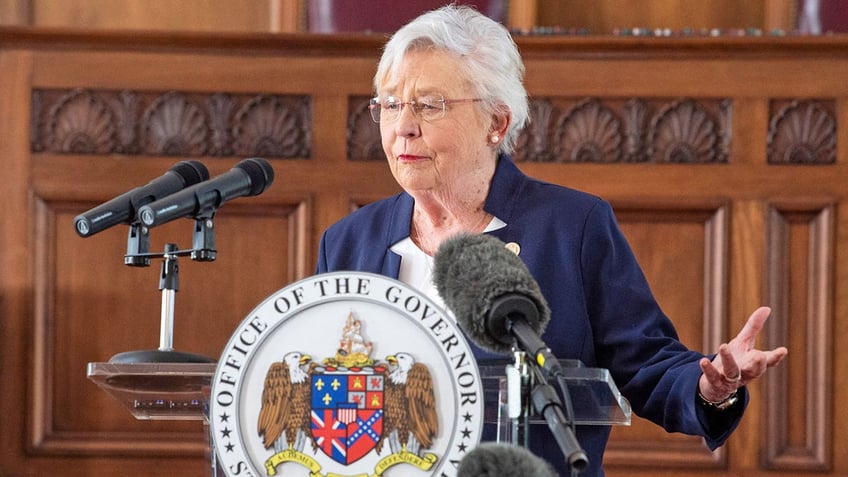 Gov. Kay Ivey answers reporters at a news briefing.