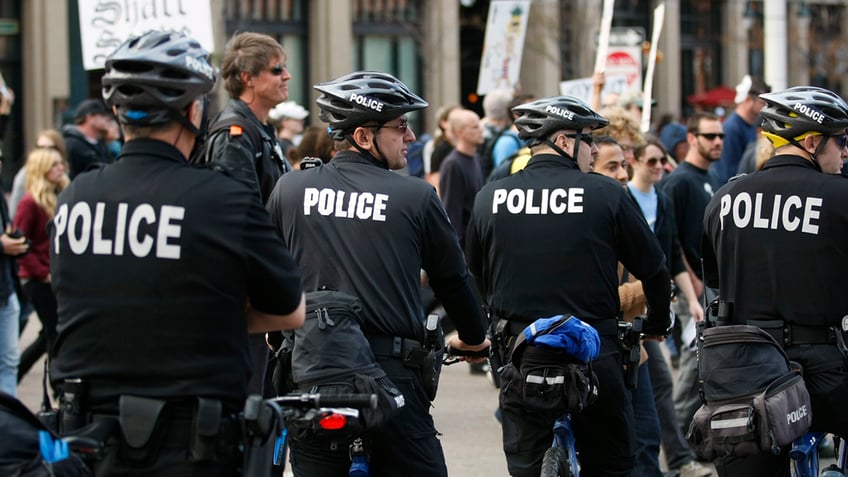 Photo showing Denver police officers riding bikes while patrolling