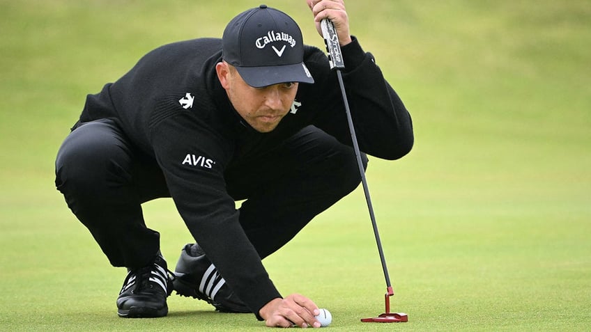 Xander Schauffele places his ball