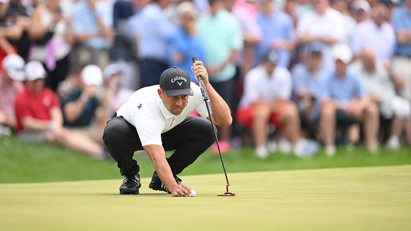 Xander Schauffele lines up ball for putt