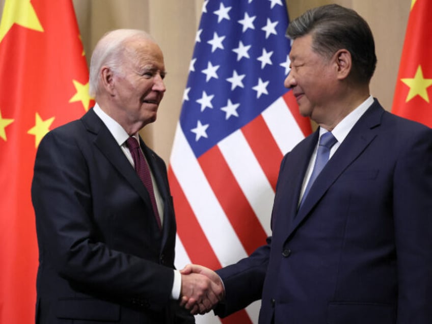 TOPSHOT - US President Joe Biden (L) shakes hands with Chinese President Xi Jinping on the