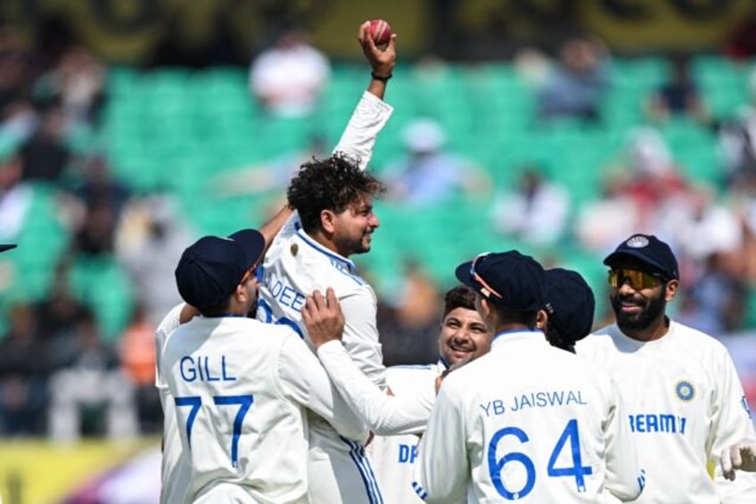 India's Kuldeep Yadav (2L) celebrates after taking five-wicket haul during the first day o