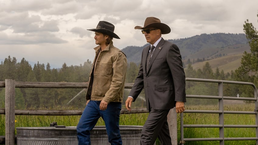 Kayce Dutton (Luke Grims) and John Dutton (Kevin Costner) walk in stride in a shot from "Yellowstone"