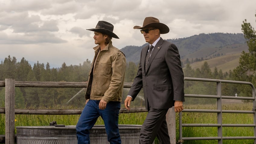 Kayce Dutton (Luke Grims) and John Dutton (Kevin Costner) walk in stride in a shot from "Yellowstone" 