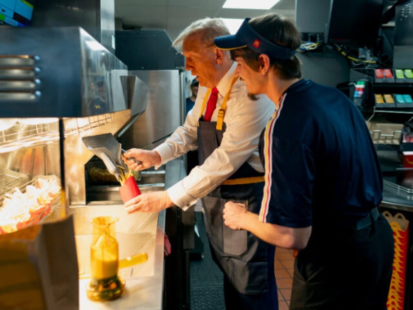 Republican presidential nominee former President Donald Trump, left, uses a frier an emplo