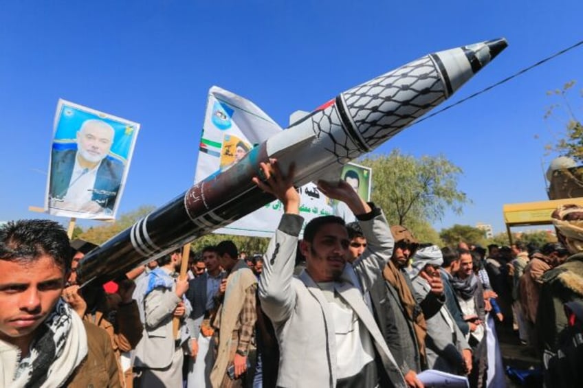 Yemenis carry a mock missile during a rally in solidarity with Palestinians, in the Huthi-