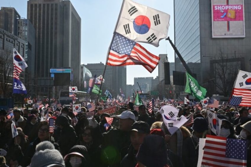 Supporters of President Yoon Suk Yeol wave South Korean and US flags ahead of the second i