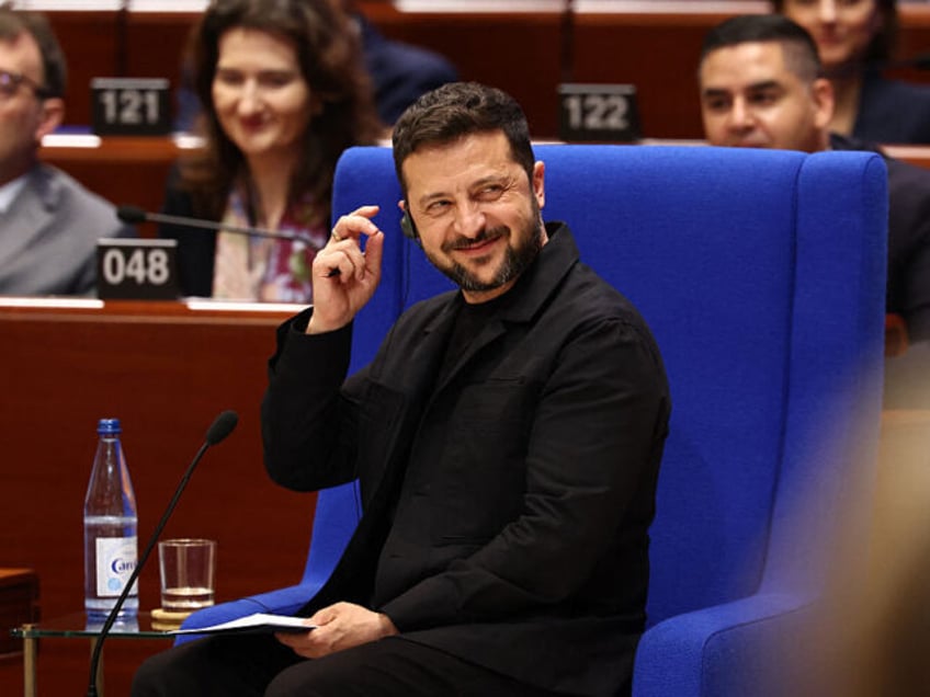 Ukraine's President Volodymyr Zelensky reacts as he addresses members of the Parliame
