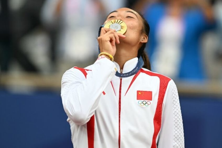 Golden moment: China's Zheng Qinwen poses with her medal on the podium