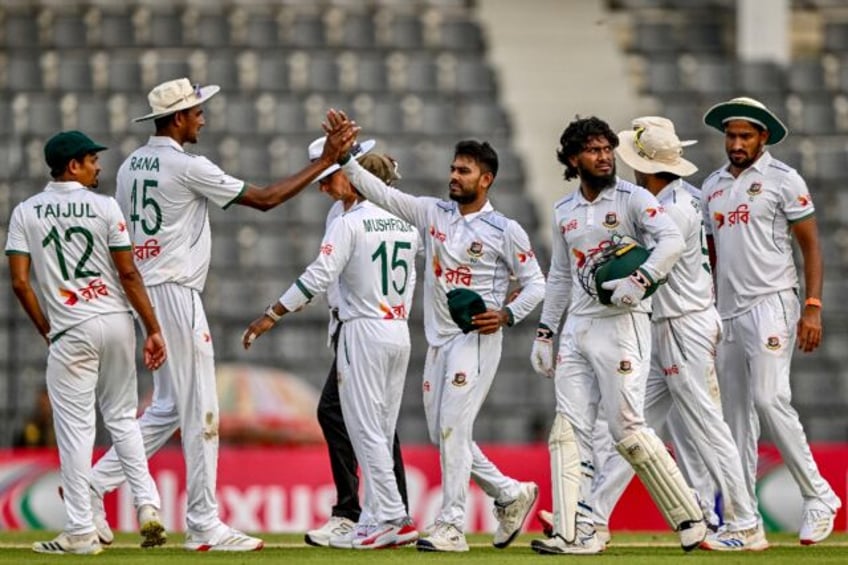 Bangladesh’s Mehidy Hasan Miraz (C) celebrates after taking the wicket of Zimbabwe’s