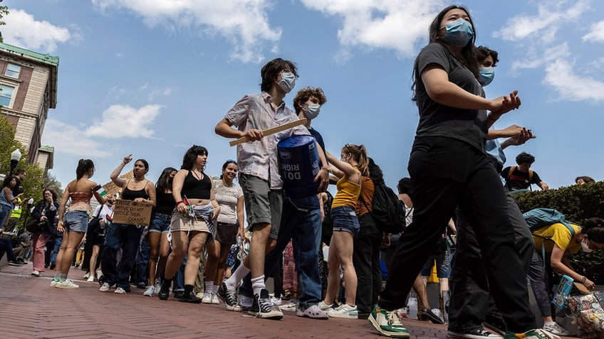 Student protesters march around their encampment on the Columbia University campus